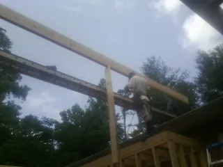 Carpenter setting a ridge beam over a new addition frame — Ice Dam Removal by Roofing Brothers in Smelterville