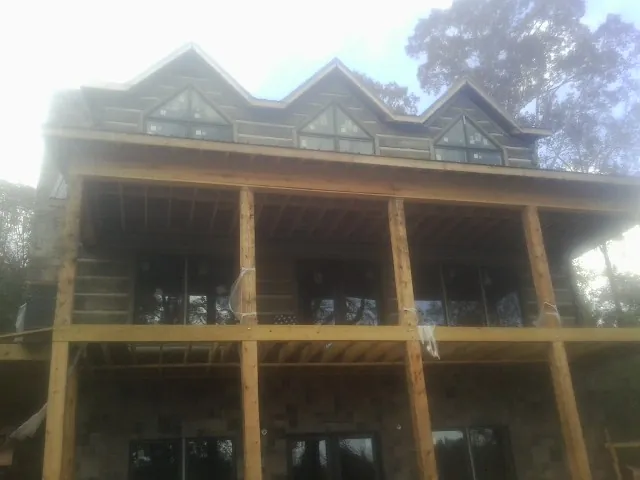 Dormers and porch framing on a large log home under construction — Roof Coating work by our crew in Smelterville