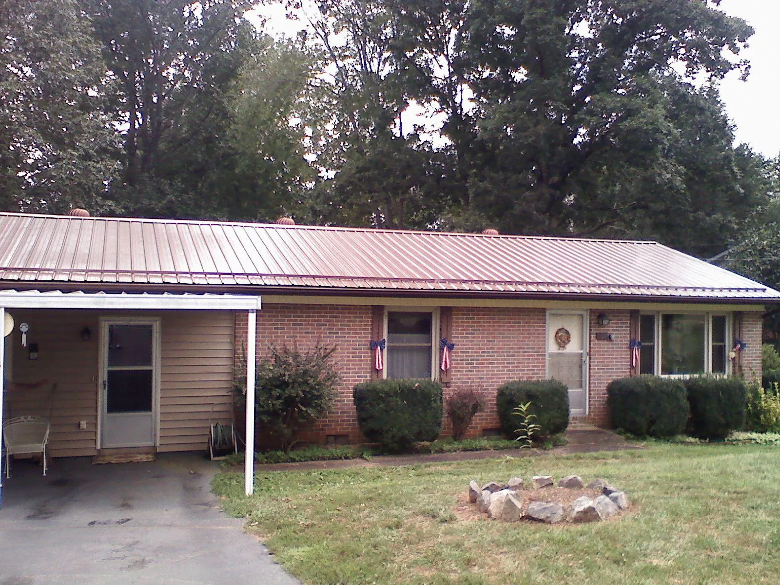 Bronze metal roof and carport on a brick ranch home — Roof Repair work by our crew in Smelterville