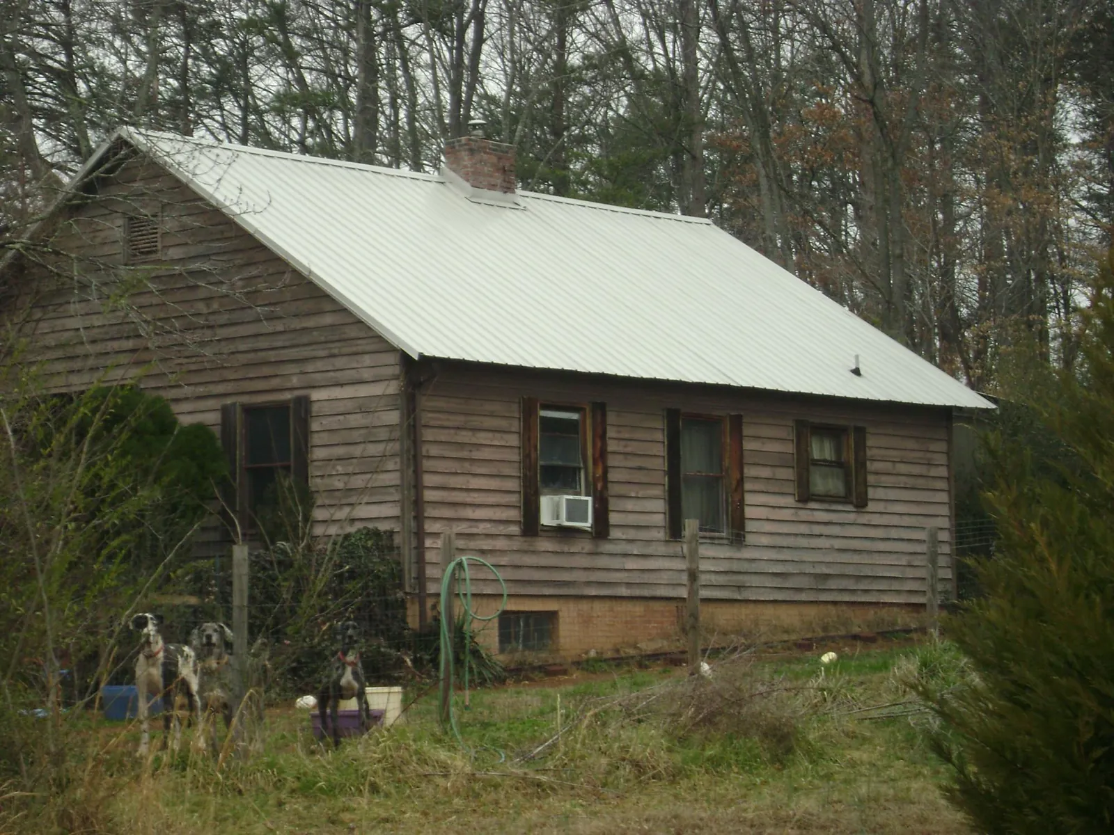 White metal roof on an old wood sided farmhouse, from a Metal Roof Installation job in Smelterville